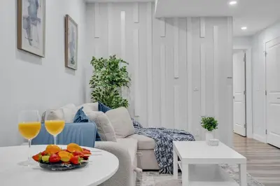 a living room with a couch and a table with wine glasses at Basement in Calgary - 10 Mins from Calgary Airport in Calgary