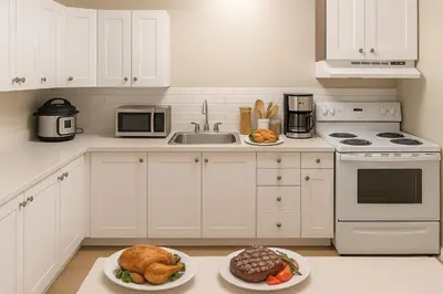a white kitchen with two plates of food on the counter at Bright Downtown Room Walk Everywhere Aurora Nearby in Whitehorse