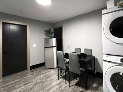 a dining room with a table with chairs and a microwave at Spacious 2-Bedroom Retreat in Burnaby in Burnaby
