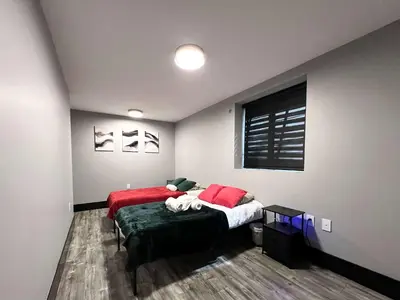 a bedroom with two beds and a green ottoman at Spacious 2-Bedroom Retreat in Burnaby in Burnaby