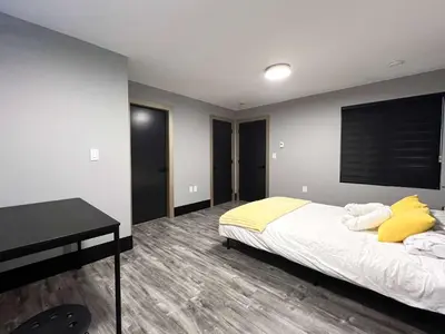 a bedroom with a bed with yellow pillows and a desk at Spacious 2-Bedroom Retreat in Burnaby in Burnaby