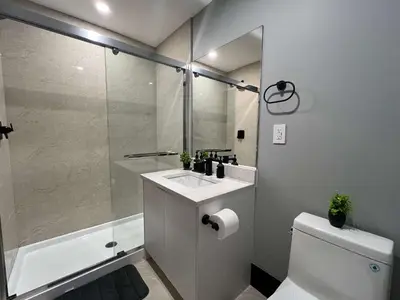 a bathroom with a shower and a sink and a toilet at Spacious 2-Bedroom Retreat in Burnaby in Burnaby