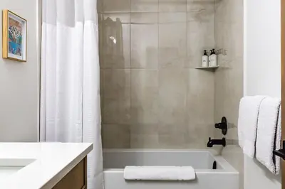 a bathroom with a white tub and a shower at Aurora Luxe - Stunning Townhouse Private Hot Tub in Canmore