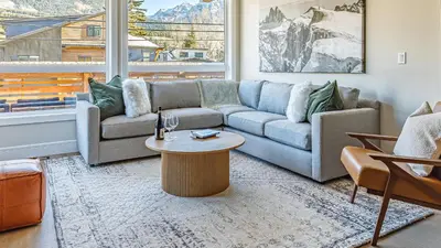 a living room with a couch and a table at Aurora Luxe - Stunning Townhouse Private Hot Tub in Canmore