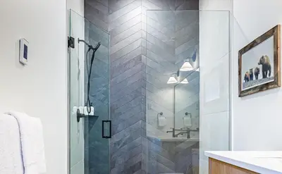 a shower with a glass door in a bathroom at Aurora Luxe - Stunning Townhouse Private Hot Tub in Canmore