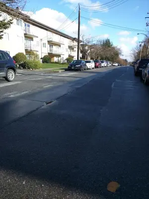 an empty street with cars parked on the side of the road at One Bedroom Suite in perfect location Vancouvers Mount Pleasant in Vancouver