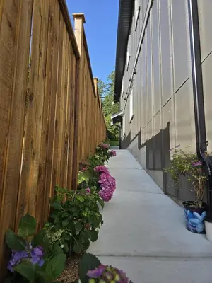 a fence with flowers on the side of a sidewalk at Oakview Hideaway in Victoria