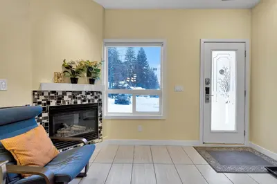 a living room with a fireplace and a window at banff woods lodge in Canmore