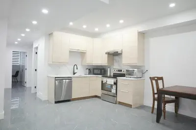 a kitchen with white cabinets and a wooden table at 5003R New Luxury Walkout Suite Near Calgary University in Calgary