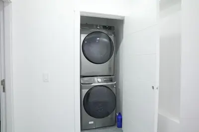 two washing machines sitting in a room at 5003R New Luxury Walkout Suite Near Calgary University in Calgary