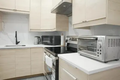 a kitchen with wooden cabinets and a microwave at 5003R New Luxury Walkout Suite Near Calgary University in Calgary