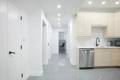 a kitchen with white cabinets and a stainless steel dishwasher at 5003R New Luxury Walkout Suite Near Calgary University in Calgary