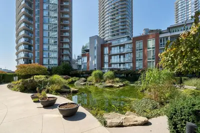 a garden in a city with tall buildings at Cozy Urban Living! 2 mins from BC place, private parking ! in Vancouver