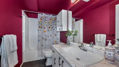 a bathroom with a sink and a toilet and pink walls at Knockan Hill Rentals - Ground Floor Suite in Victoria