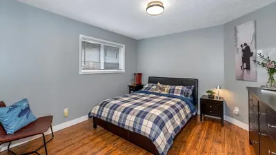 a bedroom with a bed and a table and a window at Knockan Hill Rentals - Ground Floor Suite in Victoria