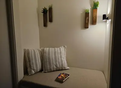 a couch with a pillow and a book on it at Cowichan Valley Retreat with Sauna & Free EV Charger in Duncan