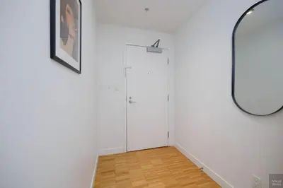 a hallway with white walls and a mirror at Spacious 2BD in Vancouver Patio with Ocean View in Vancouver