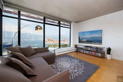a living room with a couch and large windows at Spacious 2BD in Vancouver Patio with Ocean View in Vancouver