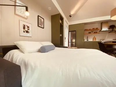 a large white bed in a room with a kitchen at Fern's Edge in Port Renfrew