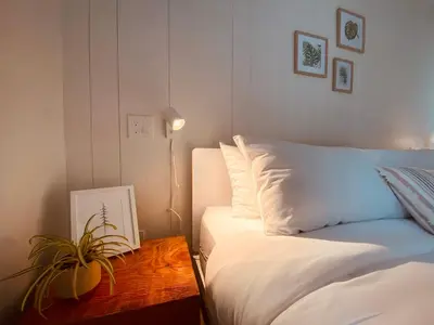 a bedroom with a bed and a table with a plant at Fern's Edge in Port Renfrew