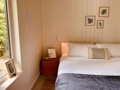 a bedroom with a bed and a window at Fern's Edge in Port Renfrew