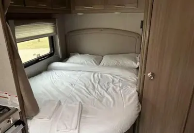 a small bed in the back of an rv at Prairie Junction Resort - Furnished RV Apartments in Stettler