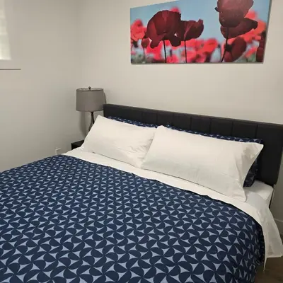 a bedroom with a bed with a blue and white comforter at Spacious 2 Bedroom Suite in Edmonton in Edmonton