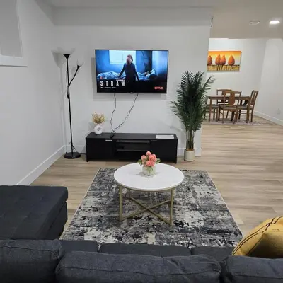 a living room with a couch and a tv on the wall at Spacious 2 Bedroom Suite in Edmonton in Edmonton
