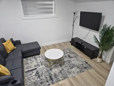 a living room with a couch and a tv at Spacious 2 Bedroom Suite in Edmonton in Edmonton