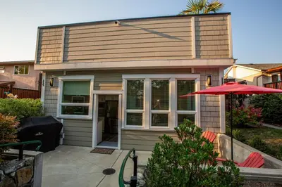 a small house with a red umbrella in front of it at Sidney Solace 1BR Suite Minutes from Waterfront in Sidney