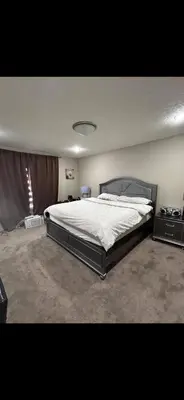 a bedroom with a large bed in a room at Coastal Comforts Villa in Airdrie