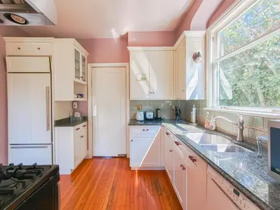 a kitchen with white cabinets and a window at Cozy Private Bedroom Suite in UBC Campus in Vancouver