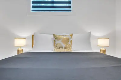 a bedroom with a bed with two lamps on it at The Olaf in Trendy Killarney - Close to Everything in Calgary