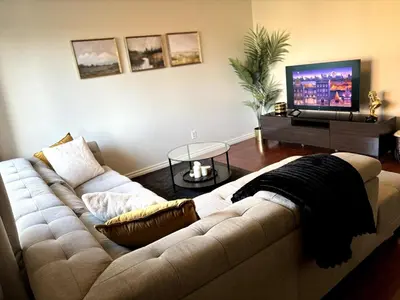 a living room with a couch and a flat screen tv at Falcon Escape in Calgary