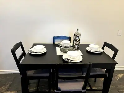 a black table with four chairs and a vase on it at Falcon Escape in Calgary