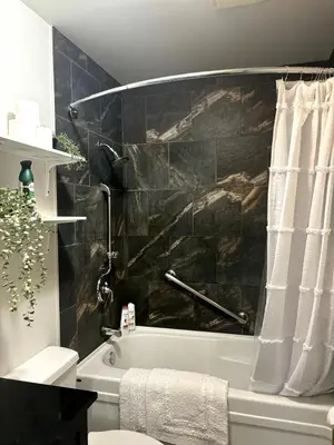 a bathroom with a bath tub with a black wall at Falcon Escape in Calgary