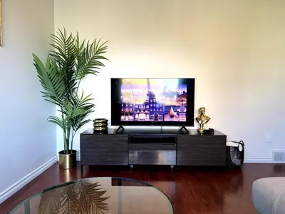 a living room with a flat screen tv on a entertainment center at Falcon Escape in Calgary