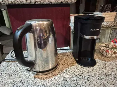 a coffee pot sitting on a counter next to a coffee maker at Abbie's Cozy Single Rooms in Maple Ridge District Municipality