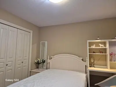 a bedroom with a white bed and a mirror at Abbie's Cozy Single Rooms in Maple Ridge District Municipality