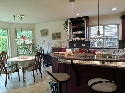 a kitchen with a counter and a table and chairs at Abbie's Cozy Single Rooms in Maple Ridge District Municipality