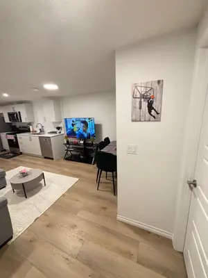 a living room with a kitchen and a room with a table at Chezeey Home in Edmonton