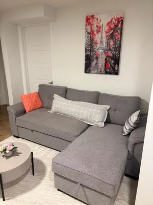 a living room with a gray couch and a table at Chezeey Home in Edmonton