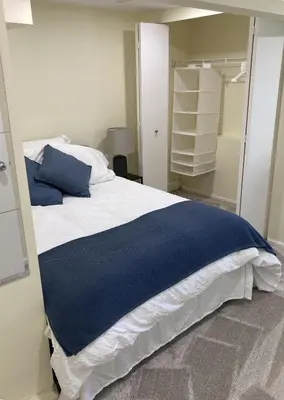 a bedroom with a bed with a blue blanket on it at Private Suite in Vancouver in Vancouver