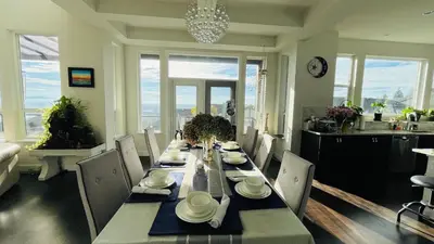 a dining room with a long table and chairs at Carrie's The Gentle Nest No 2 in Coquitlam