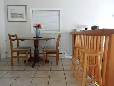 a kitchen with a table and chairs and a vase with flowers at Beach front cabin near Nelson, BC in Nelson