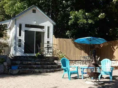 a table and chairs with an umbrella in a yard at Beach front cabin near Nelson, BC in Nelson
