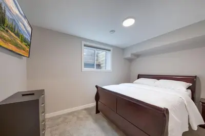 a bedroom with a large bed and a window at Stunning NEW 3 Bedroom Mountain View Condo in Radium Hot Springs