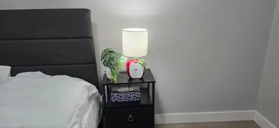 a lamp on a night stand next to a bed at Glacier Comfort Living Suite in Calgary