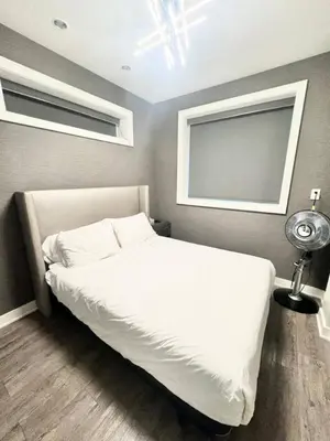 a bedroom with a white bed and two windows at Kitsilano Retreat at Private 3 Bed with Parking and BBQ in Vancouver