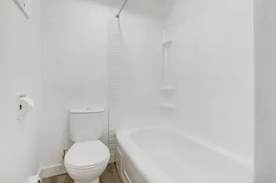 a white bathroom with a toilet and a tub at Gateway Suites Single Private Room Near Banff and Canmore in Canmore
